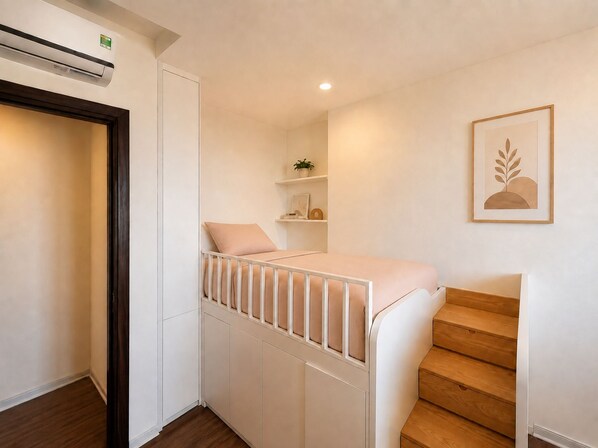 A bedroom with a bunk bed, a wooden staircase, a wall-mounted air conditioner, and a framed picture. - VEC Homes - Near Vietnam Exposition Center VEC Dong Anh (Hanoi)
