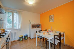 A compact kitchen with a stove, sink, and window with curtains. - Torbole Lake Front (Arco)