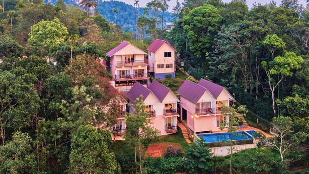 Una propiedad en la ladera con varias casas, piscina y abundante vegetación.