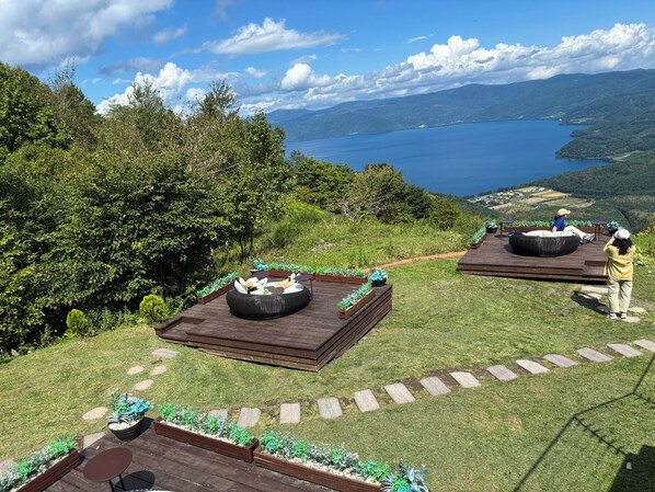 Un espace extérieur agréable, aménagé avec des sièges et offrant une vue sur un lac.