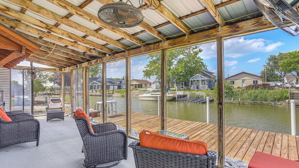 A covered outdoor area with wicker furniture and a view of a water body. - 75' Private Dock! Waterfront Nugent's Canal Home (Port Clinton)