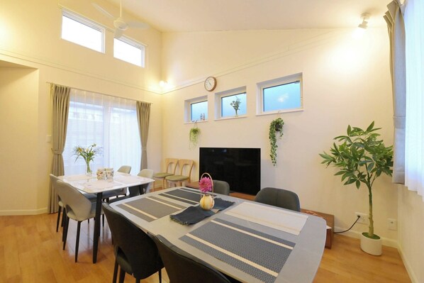 A dining area with a table set for two, a TV, and a potted plant. - Maximum 12 guests | 131 sq m private house | Free  / Nagoya City Aichi (Nagoya City)