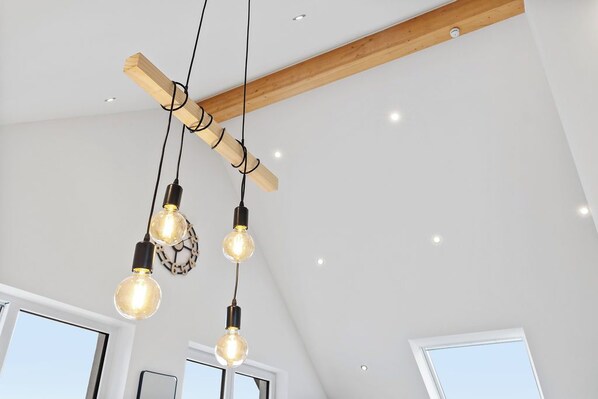 A modern interior with exposed wooden beams, pendant lighting, and large windows. - Eifelruhe Monschau, loft-style ambiance with views of nature, 3 bedrooms, 2 bathrooms, balcony, garden (Monschau)