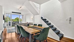 Un intérieur moderne comprenant un coin repas, un escalier et une vue sur l’extérieur.