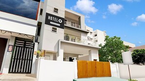 A modern hotel with a prominent sign, balconies, and a gated entrance. - Premiumcoastal Inn 3 (Kakinada)