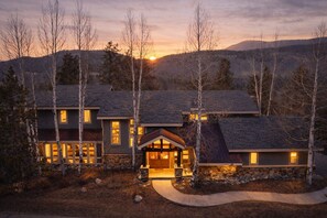 A multi-story house with a stone foundation, multiple windows, and a central entrance with a porch. - Mountain Retreat • Hot Tub | Near Keystone Resort | Keystone Alpine Haven (Keystone)