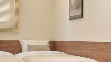 A bedroom with a wooden bed, a headboard, a window with blinds, and a framed picture on the wall.