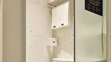 Un bany modern amb un vàter blanc, un espai de dutxa amb envàs de vidre i un lavabo blanc.