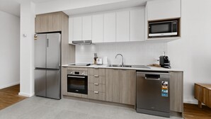 Eine moderne Küche mit Kühlschrank, Backofen, Mikrowelle und Geschirrspüler.
