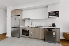 Eine moderne Küche mit Kühlschrank, Backofen, Mikrowelle und Geschirrspüler.