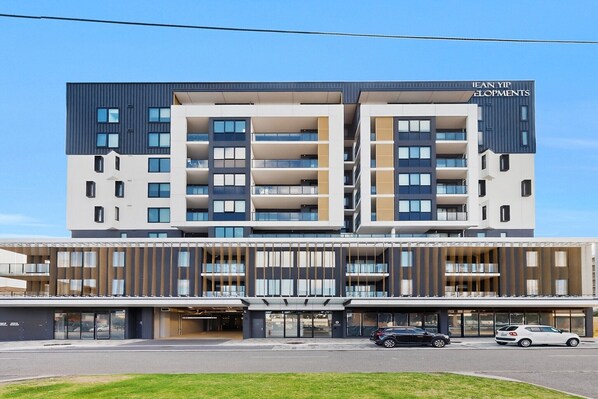 A modern hotel building with multiple balconies, a flat roof, and a sign reading 'JEAN YIP ELOPMENTS.' - Stylish 2 Bed Apartment with New Furnishings (Cannington)