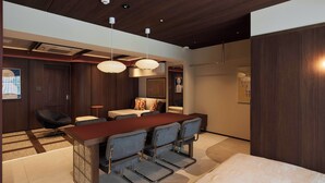 A modern interior with a wooden ceiling, recessed lighting, a central island with bar seating, and a large bed. - illi Atra Aoyama (Tokyo)
