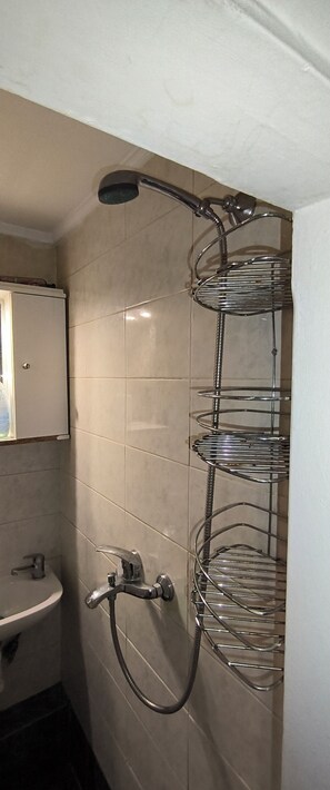 A bathroom with a shower, a sink, and a mirror. - Thessalonik Apartment-heart of the City (Thessaloniki)