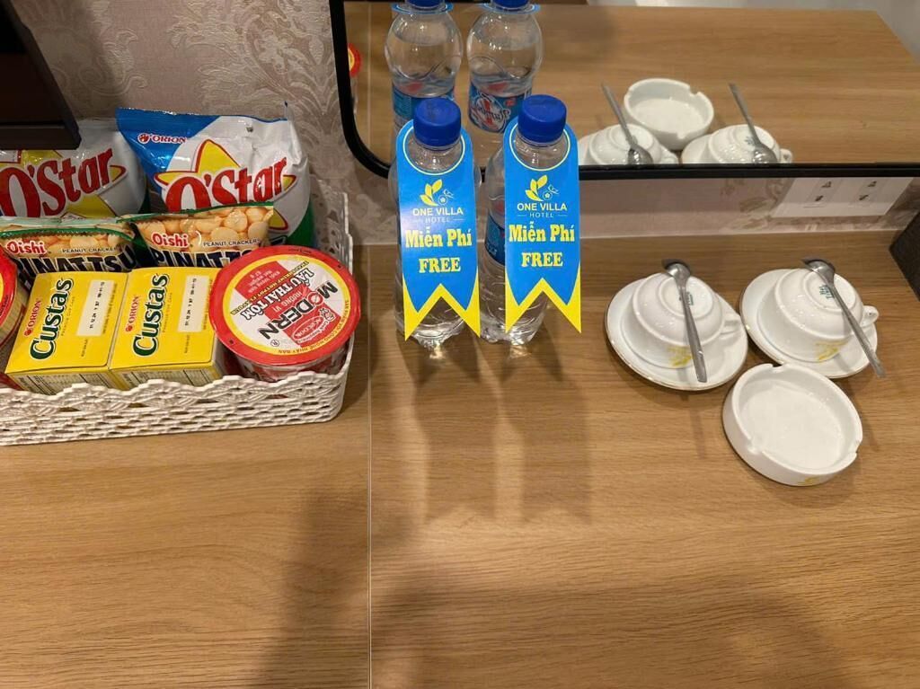 Montaje de desayuno buffet con bocadillos, agua embotellada y platos desechables.