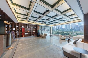 A modern interior with a city view, a reception desk, and a seating area.