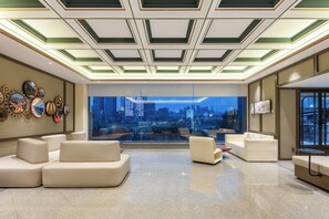 A modern living room with a city view, a sofa, a coffee table, and a wall with clocks. - Nostalgia Hotel chongqing hongyadong (Chongqing)