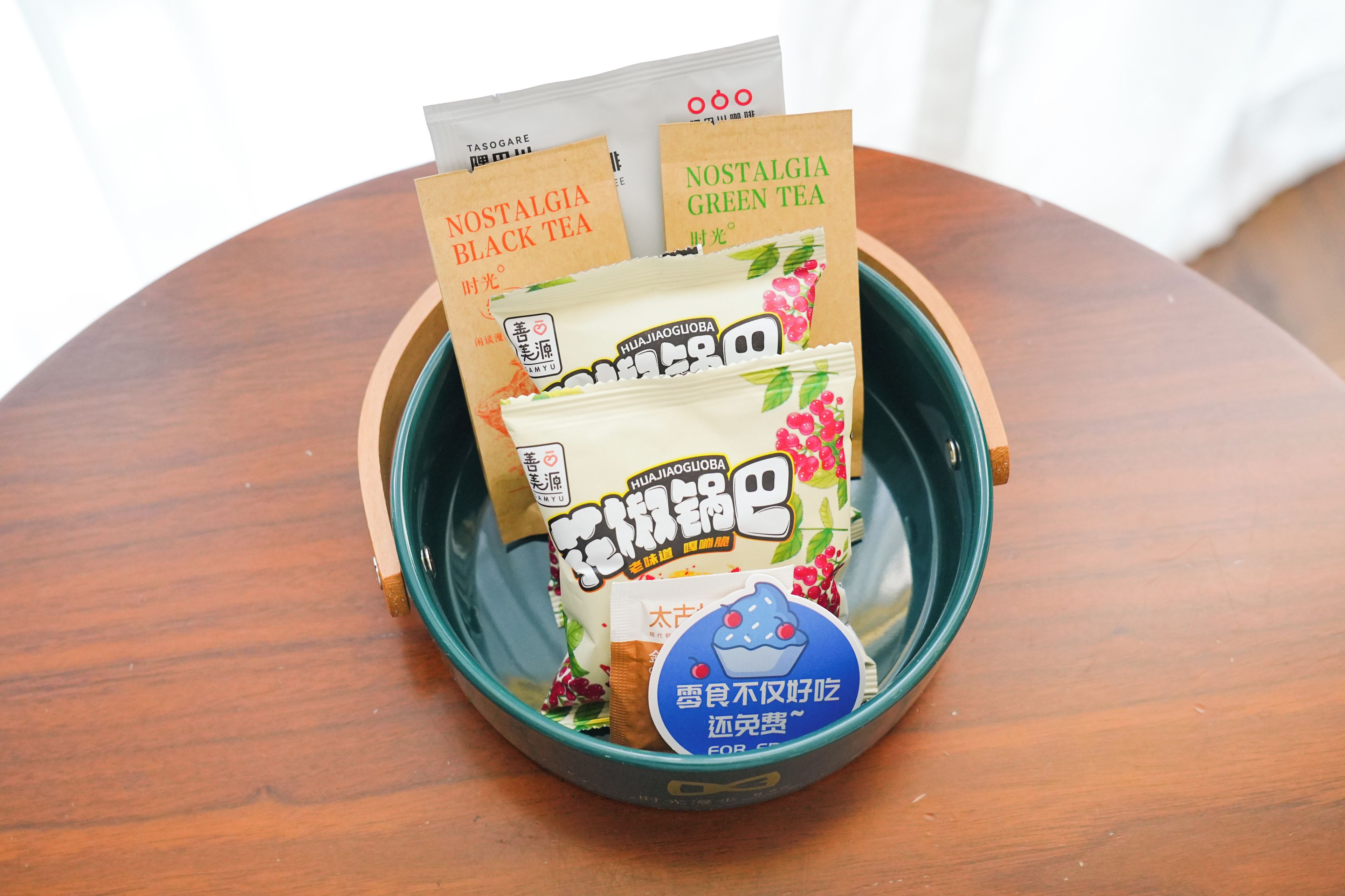 A wooden table with a bowl containing various tea packets.