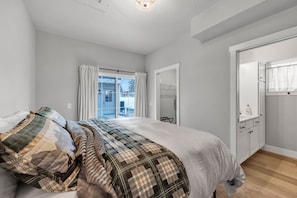 Ein Schlafzimmer mit einem Bett, einem Kleiderschrank und einem Fenster mit Vorhängen.