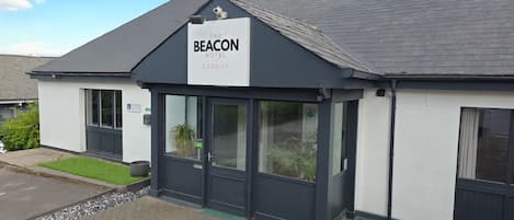 A hotel named 'The Beacon Hotel' with a sign above the entrance.