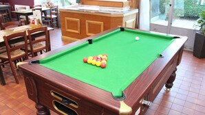 A pool table with balls, wooden chairs, and a bar area. - The Raceby Hotel, Doncaster (Doncaster)
