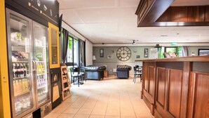 A hotel lobby with a reception desk, seating area, and vending machines. - The Reston Hotel Washington (Washington)