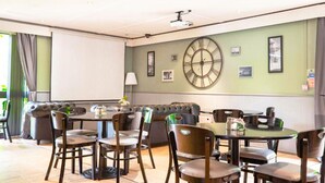 A conference room with a large clock, a projector, and a white screen. - The Reston Hotel Washington (Washington)