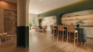 A modern kitchen with wooden cabinets, a dining area with a table and chairs, and a large window.