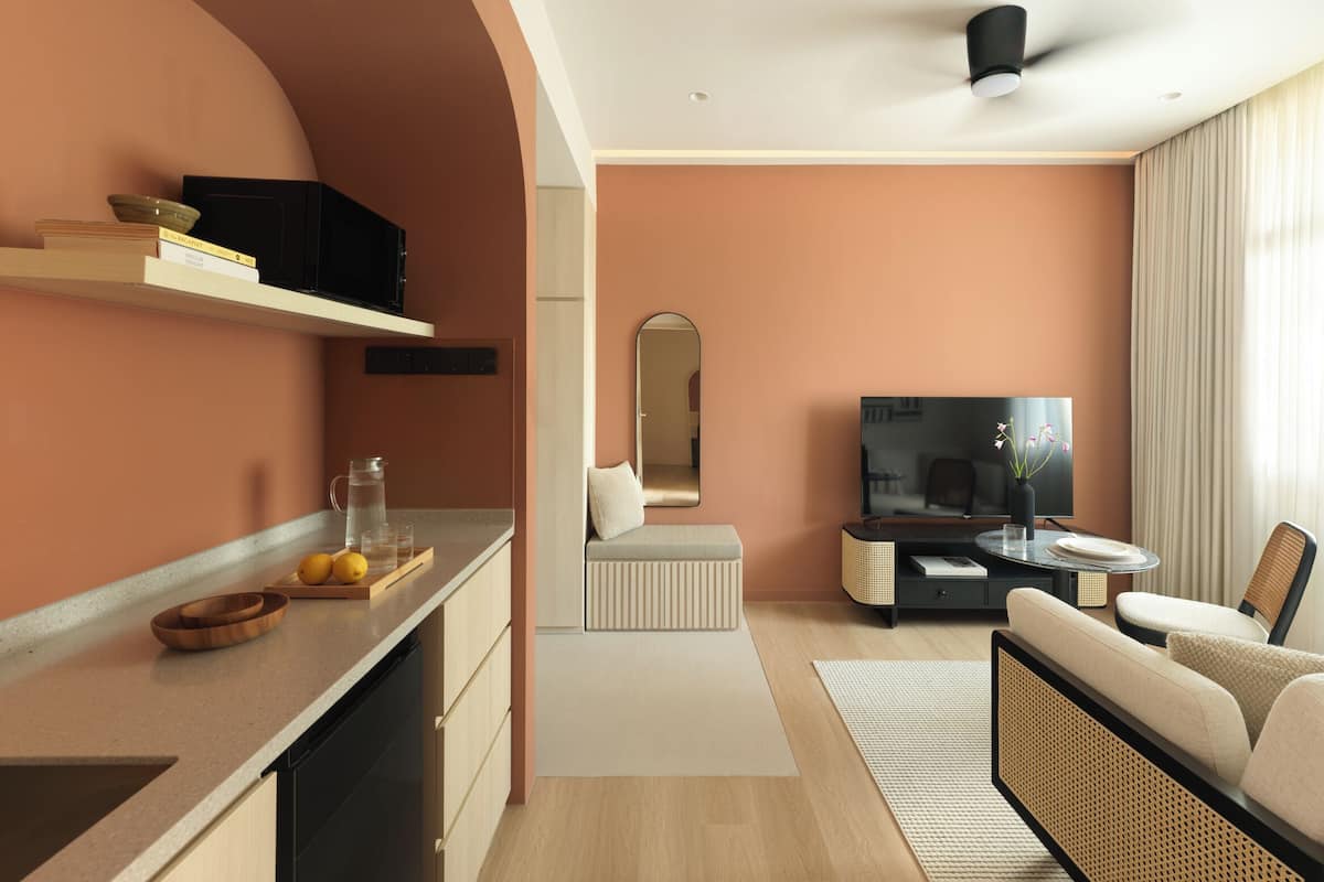 Una sala de estar moderna con televisor de pantalla plana, un sofá, una mesa de centro y un comedor con televisor y una mesita.