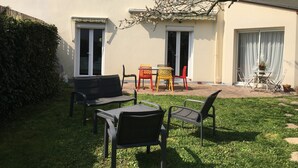 Una casa con un patio amueblado, que incluye una pequeña mesa y sillas.