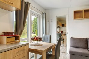 Una cocina moderna con armarios de madera, una mesa de comedor y vistas al exterior.