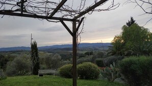 A garden with a wooden bench, a pergola, and a variety of plants. - The three owls of san gimignano (San Gimignano)