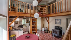 A multi-level home with a kitchen, dining area, and a loft bedroom. - Holiday Home 'Aux Agapanthes', Shared Pool, Private Terrace, Landscaped Park, Free Wi-Fi (Aumagne)