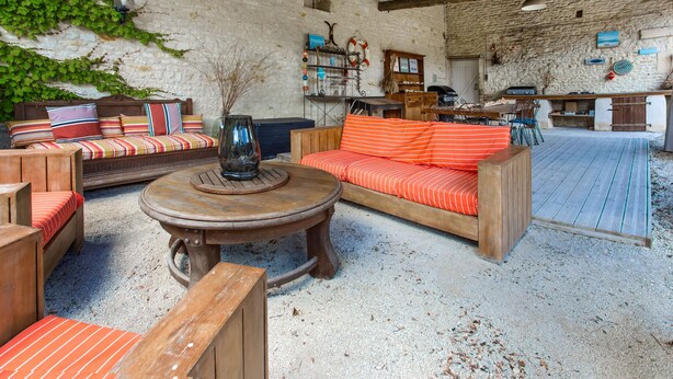A rustic interior with a stone wall, wooden furniture, and a dining area. - Holiday Home 'Aux Agapanthes', Shared Pool, Private Terrace, Landscaped Park, Free Wi-Fi (Aumagne)