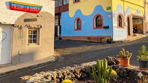 A colorful building with a sign 'Meson La Barca' and a solar panel sign. - 7 Calcosas (Valverde)