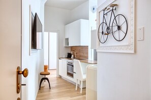A modern kitchen with white cabinetry, a wooden countertop, and a bicycle wall art piece. - Easylife - Milano - Bertacchi 1S - Milano  (Milano)