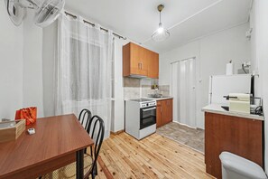 Eine kleine Küche mit Herd, Backofen und Holzschränken.