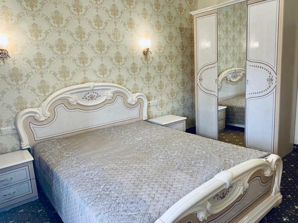 Un dormitorio con cama, mesita de noche, cómoda y espejo.