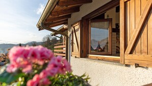 Un edificio de madera con balcón, ventana con vistas y puerta.