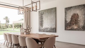 Un comedor moderno con una mesa de madera, seis sillas y arte abstracto en la pared.