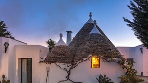 Un edificio tradicional con techos cónicos, una puerta y un banco pequeño.