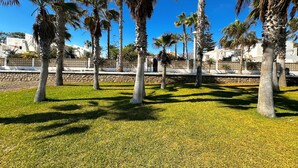 A park with palm trees and a stone wall. - La Caleta 'Mediterranean beachfront house' (Caleta de Vélez)