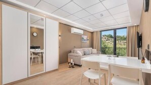 Ett modernt hotellrum med en matplats, en soffa och ett stort fönster med utsikt.