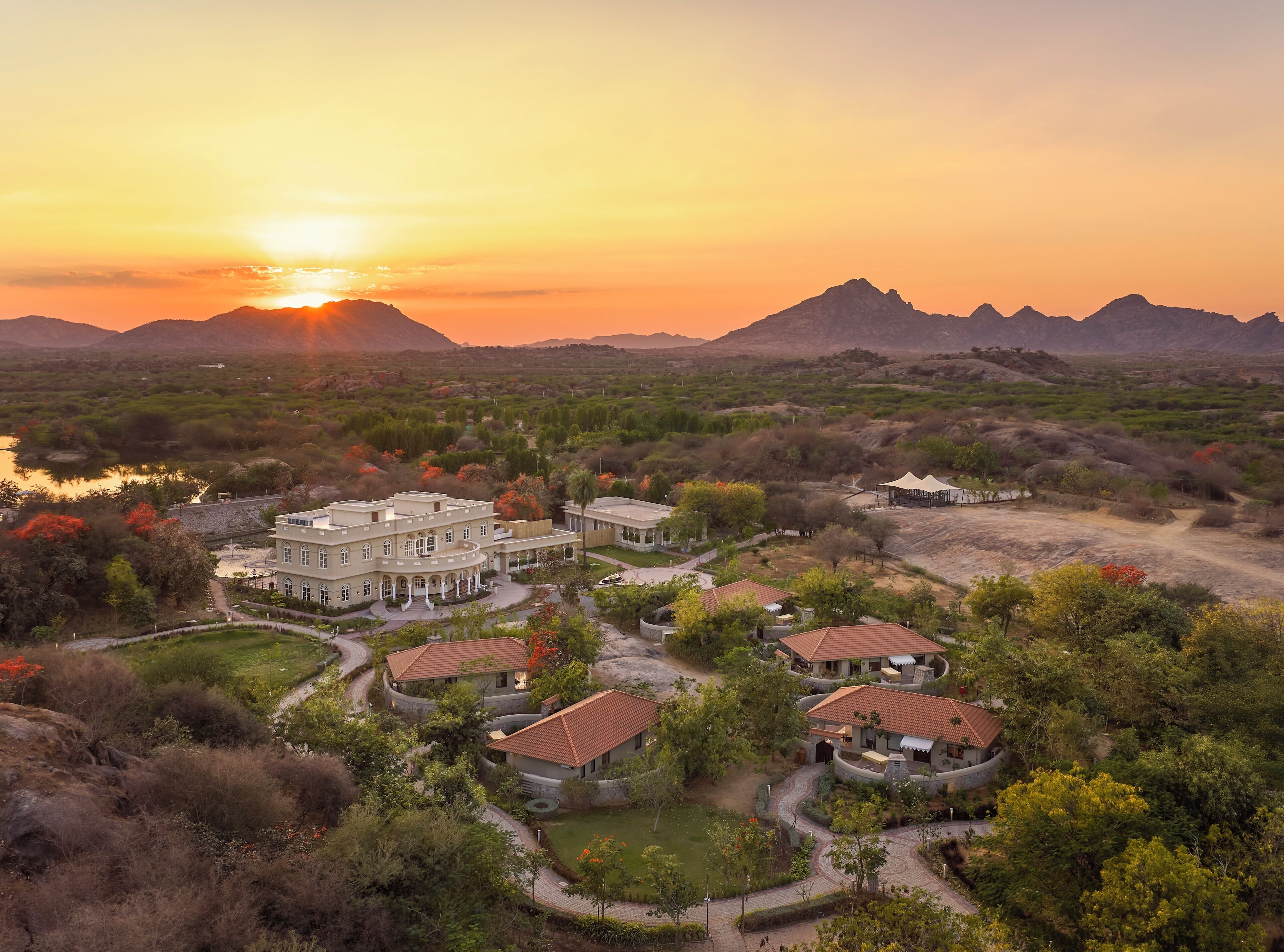 A large resort with multiple buildings, a central courtyard, and surrounding natural landscape.