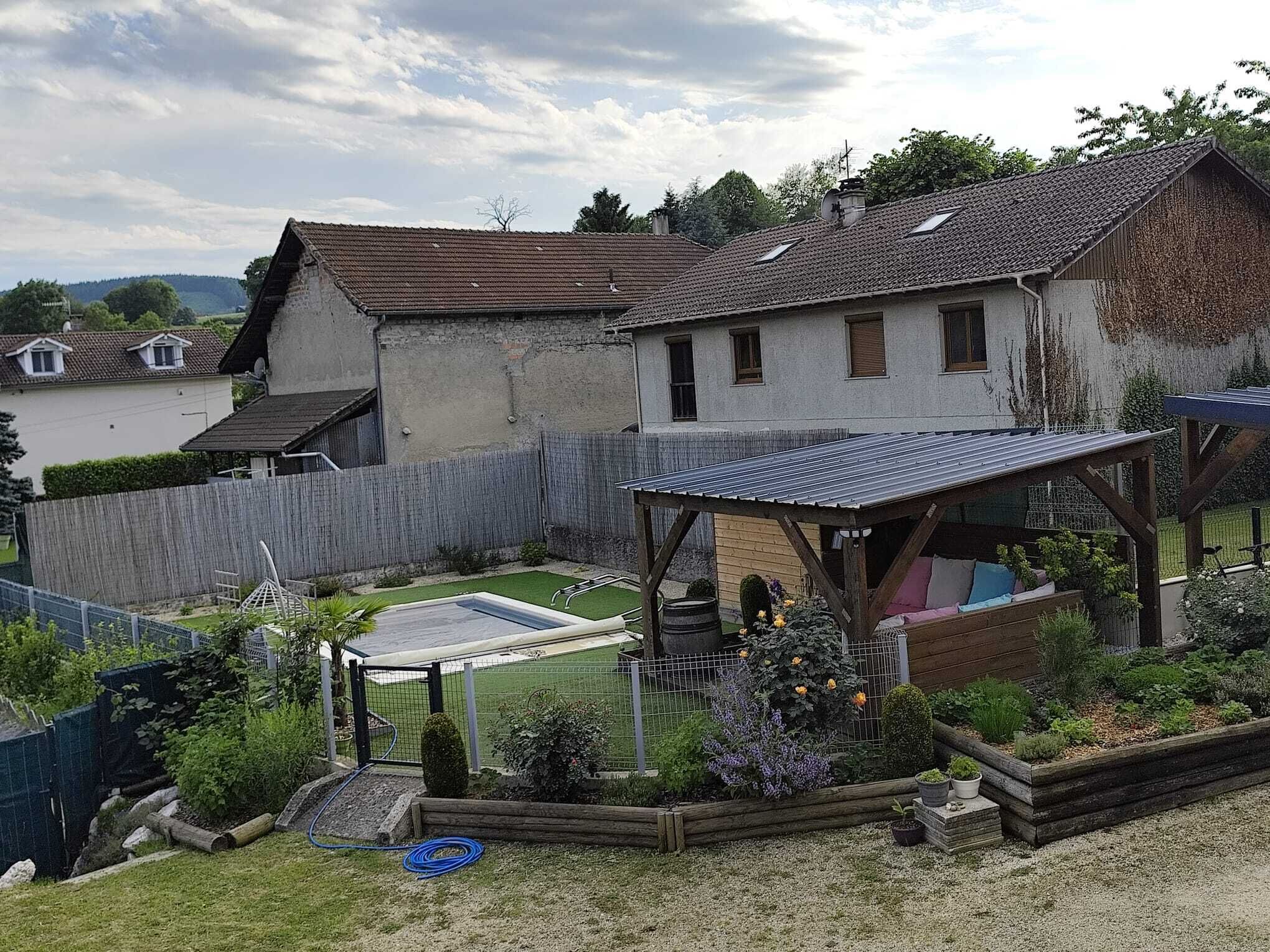 Ein Wohnhaus mit eingezäuntem Garten, einer überdachten Terrasse und einem Swimmingpool.