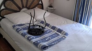A bed with a decorative headboard, a small bedside table with a lamp, and wall-mounted decorations.