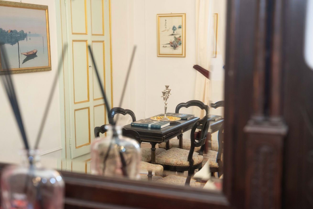 Uma área de jantar com mesa, cadeiras e castiçal.