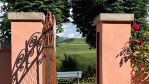 Una entrada protegida con una banca y vistas a un paisaje verde.