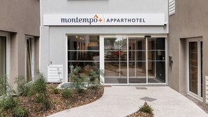 Moderni kerrostalo, jonka julkisivussa on kyltti, jossa lukee: »montempo | APPARTHOTEL».