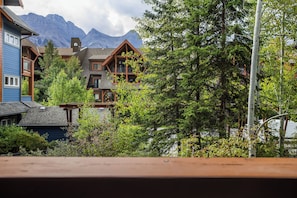 A residential area with multiple houses, some with balconies, surrounded by lush greenery and mountains in the background. - Luxury Retreat | Heated Pool, Hot Tubs | Sleeps 8 (Canmore)