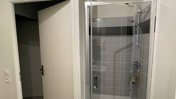 Een douche, een haardroger, handdoeken, toiletpapier